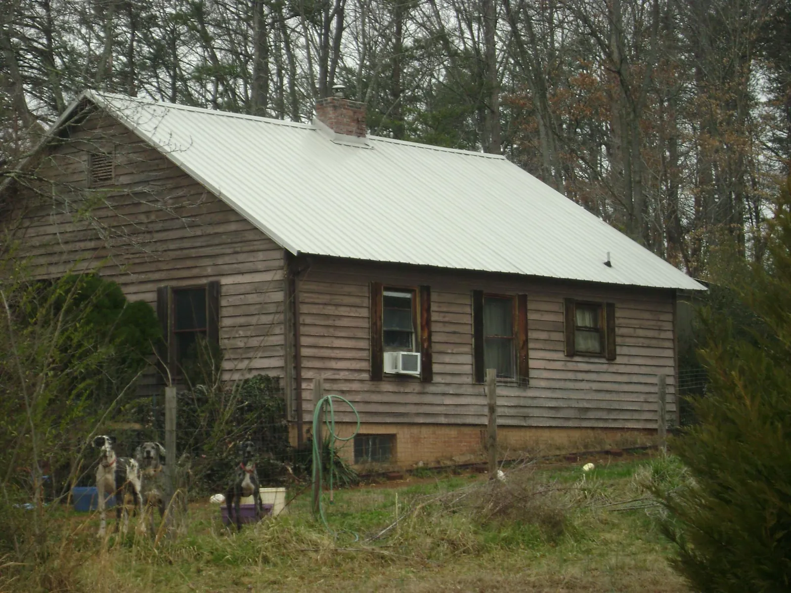 White metal roof on an old wood sided farmhouse, from a Metal Roof Installation job in Henrietta